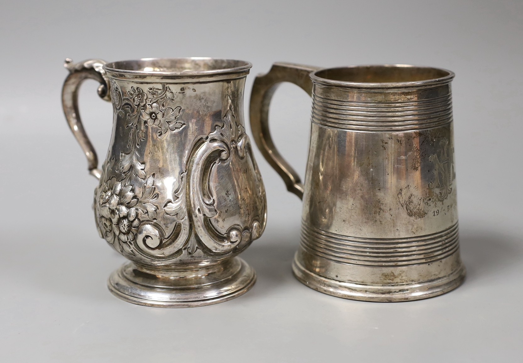 A George V silver mug, with reeded bands, Elkington & Co, Birmingham, 1935, 11.5cm and a Victorian repousse silver baluster mug, Robert Harper, London, 1862, 23.8oz.